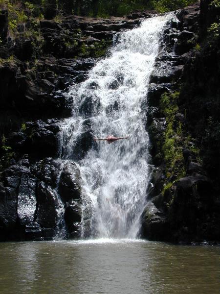 Cliff diver jumping from the falls
