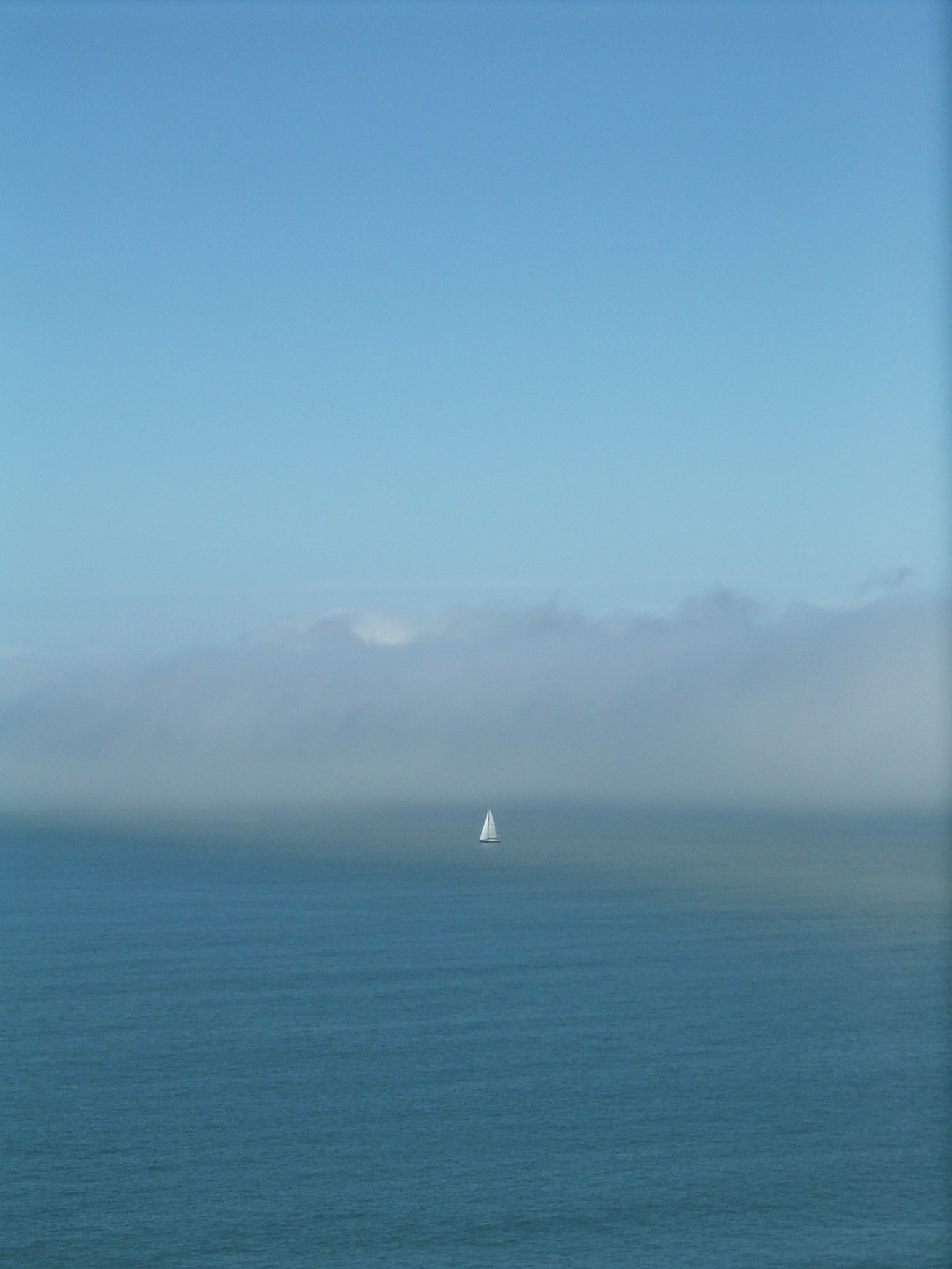 The fog, a sailboat looking at it