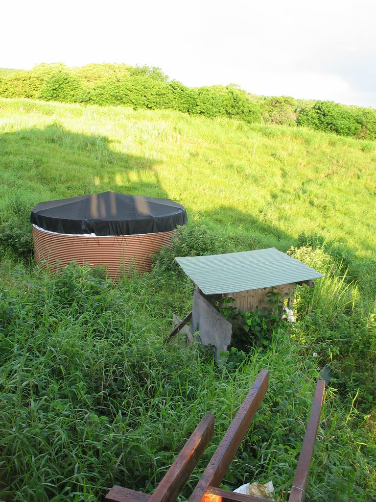 Outhouse, catchment tank, honokaa lanai and shadow